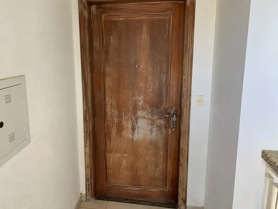 Porta de madeira opaca e marcada antes da restauração