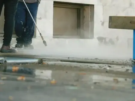 Jato de água de alta pressão limpando um piso de concreto